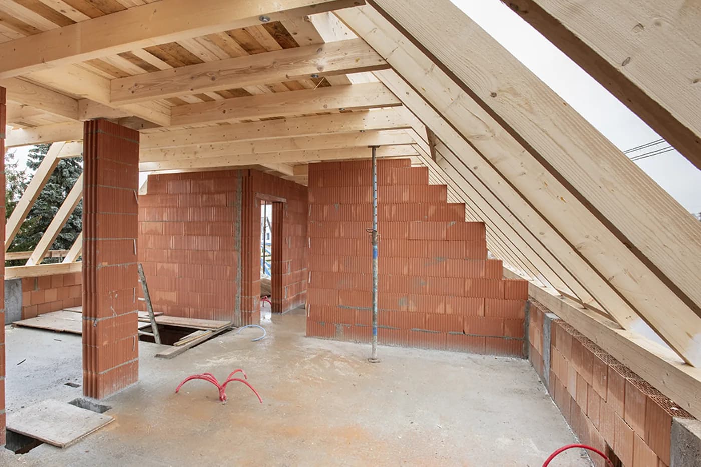 Neuer Dachstuhl aus Holz im Rohbau über gemauerten Wänden