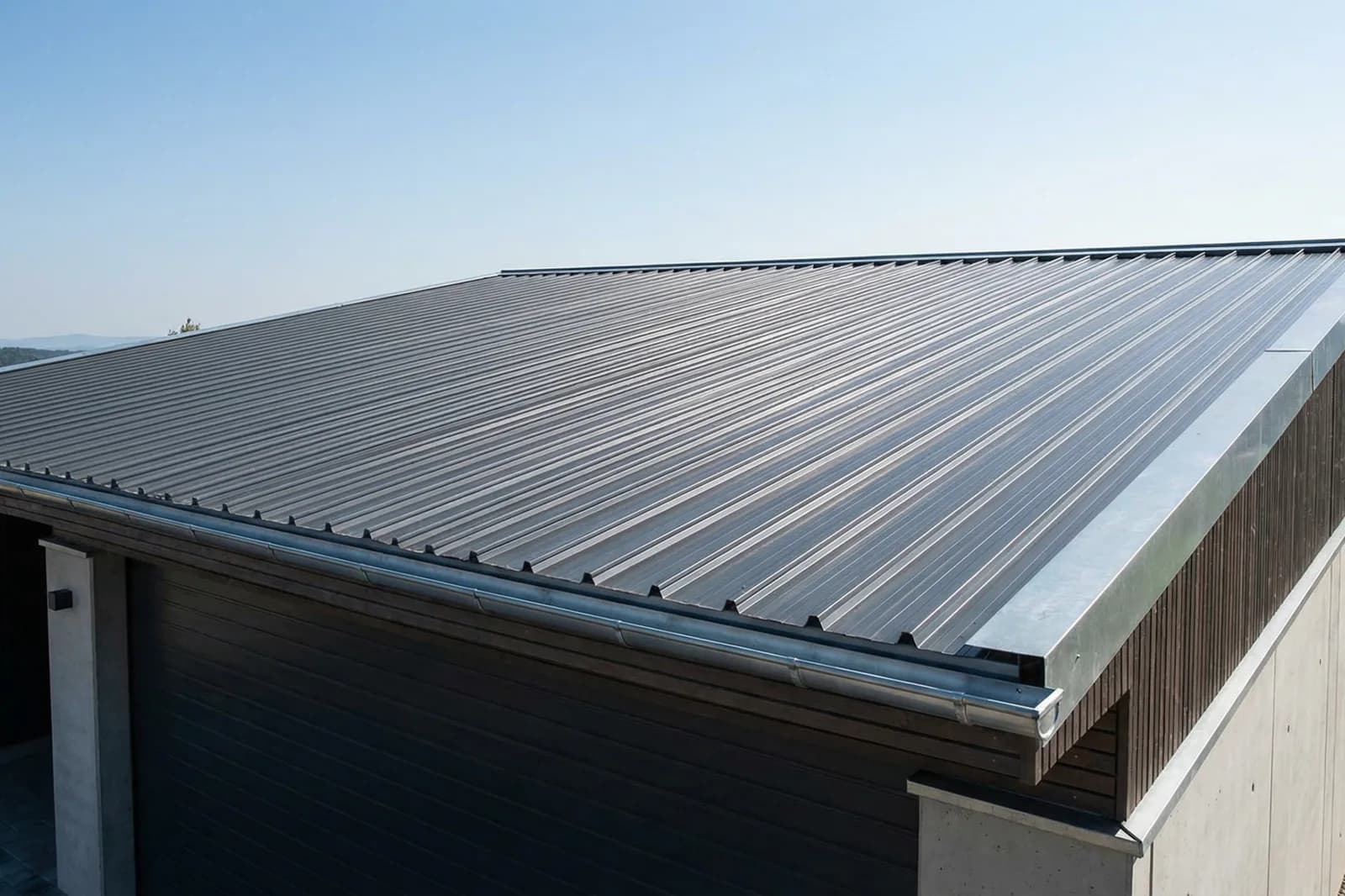Modernes Gebäude mit anthrazitfarbenem Metalldach in flacher Neigung