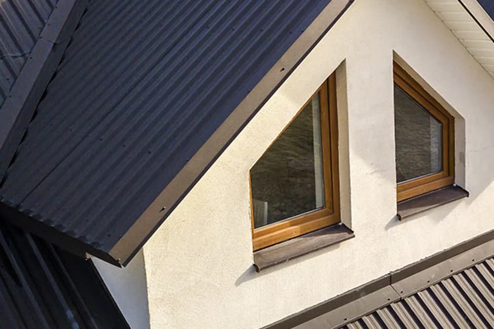 Wohnhaus mit dunklem Profilblech-Metalldach und Gaube
